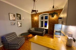 cocina y sala de estar con sofá y mesa en Apartament Odrzanka, en Gryfino