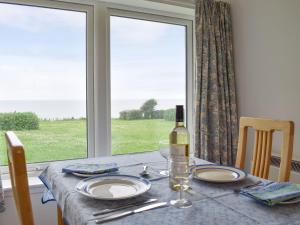 a table with a bottle of wine and a glass at 3 Covesea Village in Duffus
