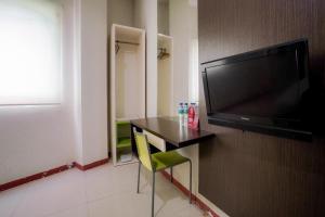 a room with a table and a flat screen tv at RedDoorz near Pantai Pede in Labuan Bajo +24 photos