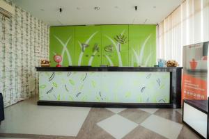 a lobby with a green wall with plants on it at RedDoorz near Pantai Pede in Labuan Bajo