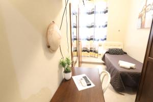 uma pequena sala de estar com uma mesa e uma cama em Carlo Goldoni Hotel em Milão