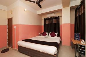 a bedroom with a bed with red and white stripes at Prabha Palace Lodge in Kamakhya