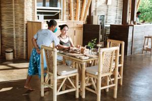 a woman and a girl sitting at a table at The Seraya Resort Komodo in Labuan Bajo