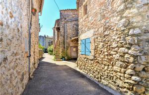 un callejón en un antiguo edificio de piedra con una ventana azul en Amazing Home In Goudargues With Kitchen, en Goudargues