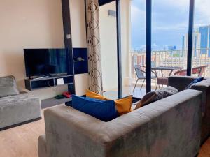 a living room with a couch and a television at THE BASE holiday in in Pattaya Central