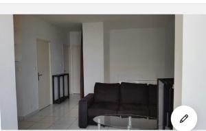 a living room with a couch and a glass table at Appartement vue Mer Sanguinaires à 5min des plages in Ajaccio
