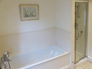 a bath tub in a bathroom with a shower at Chareside Cottage in Corbridge