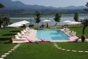 a swimming pool with lawn chairs and umbrellas at Villa Baroni in Lomnago