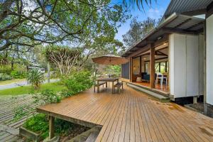 a wooden deck with a table and an umbrella at Laguna in Point Lookout