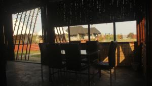 a table and chairs sitting in front of a window at Chanaka Eco Camp ( Adventure Assam ) in Pakariāmukh