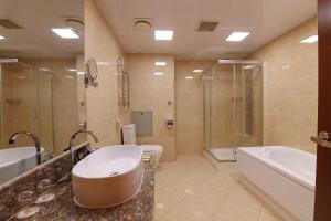 Premium Hotel Ulaanbaatar في أولان باتور: حمام مع حوض وحوض استحمام ومرحاض