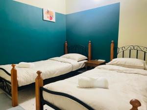 3 camas en una habitación con paredes azules en Mujito 8PAX NearTC, DinosaurLand, PoolTable, PS4, en Kuantan