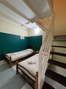 Una habitación con 2 camas y una escalera con una habitación con en Mujito 8PAX NearTC, DinosaurLand, PoolTable, PS4, en Kuantan