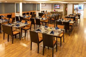 a dining room with tables and chairs in a room at 3 BY OYO Nami Residency Ahmedabad in Ahmedabad