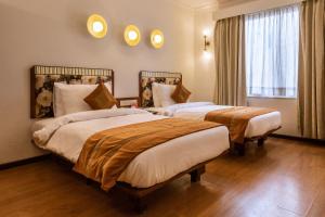a hotel room with two beds and a window at 3 BY OYO Nami Residency Ahmedabad in Ahmedabad