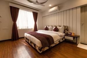 3 BY OYO Nami Residency Ahmedabad في أحمد آباد: غرفة نوم بسرير كبير ونافذة
