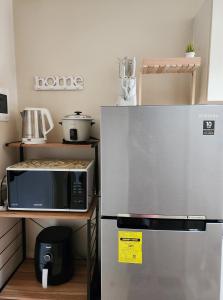 La cocina está equipada con microondas y nevera. en CunduNiAia Sunvida Tower Condominium Unit Across SM Cebu, en Cebú