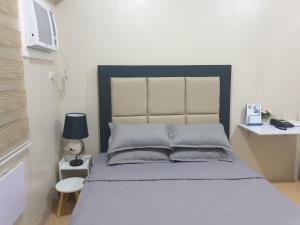 a bedroom with a bed and a desk with a lamp at CunduNiAia Sunvida Tower Condominium Unit Across SM Cebu in Cebu City