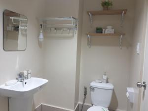 Un baño con un inodoro blanco y un lavabo. en CunduNiAia Sunvida Tower Condominium Unit Across SM Cebu, en Cebú 4 fotos más
