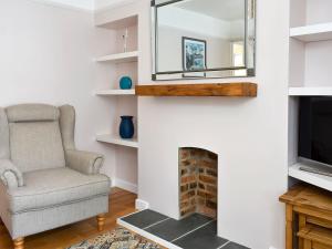 een woonkamer met een stoel en een televisie bij Dolphin Watch - Uk12237 in Newlyn