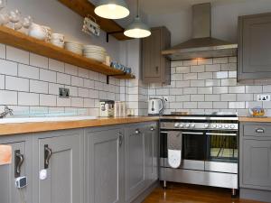 een keuken met grijze kasten en een oven. bij Dolphin Watch - Uk12237 in Newlyn