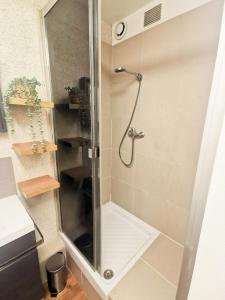 een douche met een glazen deur in de badkamer bij Loft atypique au calme avec cour privative in Bourges