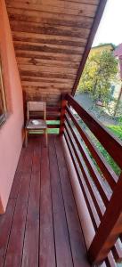 a wooden porch with a bench sitting on it at Studentiški apartamentai Palangoje in Palanga