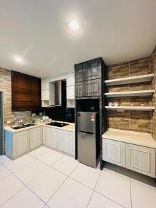 eine Küche mit schwarzen und weißen Schränken und einem Kühlschrank in der Unterkunft Kulai Lagenda Putra Corner House 古来公主城民宿 near JPO in Kulai
