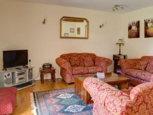 a living room with two couches and a tv at Stanley Barn in Stonehouse