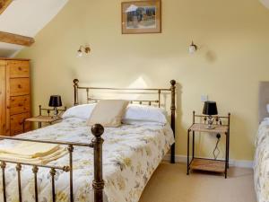 a bedroom with a bed and two side tables at Stanley Barn in Stonehouse