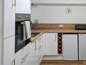 a kitchen with white cabinets and a wooden counter top at Squirrels Retreat - Uk30821 in Braithwaite