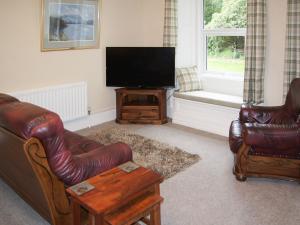 uma sala de estar com mobiliário de couro e uma televisão de ecrã plano em Squirrels Retreat - Uk30821 em Braithwaite
