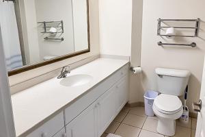 a bathroom with a sink and a toilet and a mirror at Daytona Beach Resort 805 in Daytona Beach