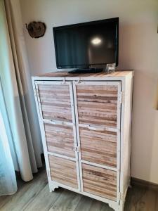 a tv on top of a wooden dresser with a tv on it at Les castagnèdes in Céret