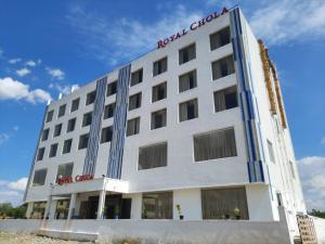 a white building with a red sign on it at Hotel Royal Chola in Kanchipuram