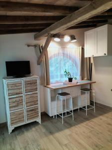 Zimmer mit einem Schreibtisch, einem TV und einem Fenster in der Unterkunft Les castagnèdes in Céret