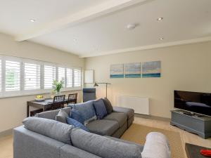 a living room with a couch and a flat screen tv at Bluestone Cottage in Welton le Wold