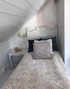 a bed in a small room with a table at Småbruket stall solheim in Rødby