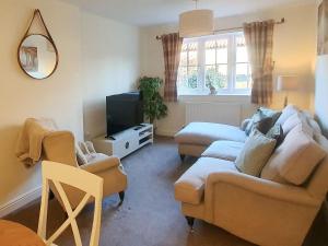 a living room with two couches and a tv at Pottergate Mews in Gilling East