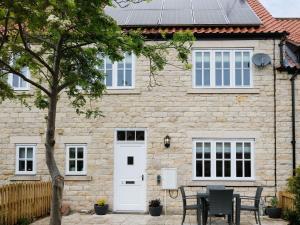 a house with a table and chairs in front of it at Pottergate Mews in Gilling East