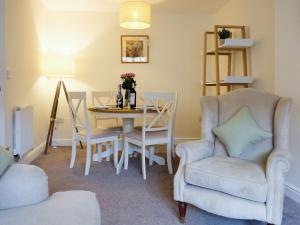 a living room with a table and a chair and a table and a chair at Pottergate Mews in Gilling East