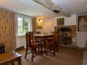 uma sala de jantar com uma mesa e cadeiras e uma lareira em Avebury Cottage em Avebury