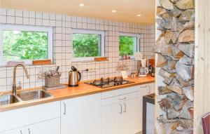 una cucina con armadi bianchi e un muro in pietra di Gorgeous Home In Tharandt With Kitchen a Tharandt