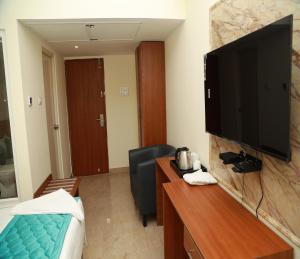 a hotel room with a television on a wall at Hotel Royal Chola in Kanchipuram