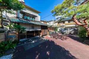 a building with a tree in front of it at Atami Onsen Yamaki Ryokan in Atami