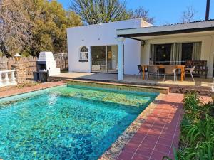 a swimming pool in front of a house at Otters' Haunt Eco Retreat in Parys