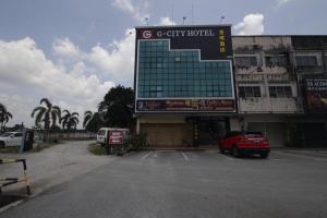 un estacionamiento con una gran señal frente a un edificio en G CITY HOTEL en Teluk Intan