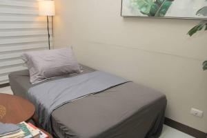 Bett mit Kissen auf dem Zimmer in der Unterkunft A2J Luxury 1BR Suite Near Venice Mall BGC Taguig in Manila