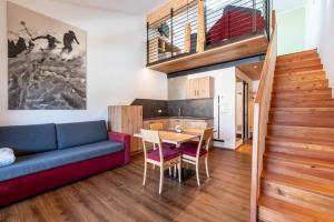 un soggiorno con divano blu e tavolo di Hohenegg Apartment Franz 2 a Campolasta