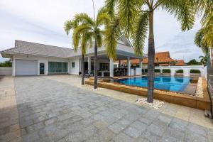 a house with a swimming pool and palm trees at Private 3 Bedroom Pool Villa! (PP10) in Hua Hin